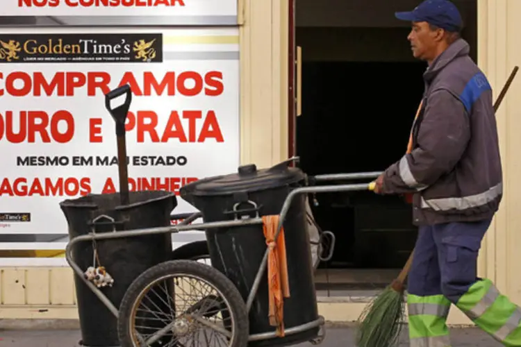 
	Gari passa em frente a uma loja em Lisboa: previs&atilde;o do governo &eacute; de um recuo de 1 por cento da economia em 2013
 (Jose Manuel Ribeiro/Reuters)