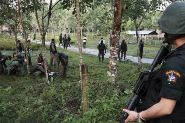 
	Equipe de seguran&ccedil;a investiga corpos de insurgentes mortos no local de um ataque a uma base militar na prov&iacute;ncia de Narathiwat, na Tail&acirc;ndia
 (REUTERS/Surapan Boonthanom)