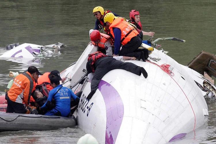 Equipe de resgate puxa passageiro de dentro de avião da TransAsia Airways que caiu em Taiwan (REUTERS/Pichi Chuang)