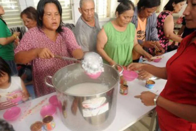 Moradores evacuados de áreas com perigo de deslizamentos se alimentam em centro de evacuação de Showlin, em Taiwan
 (Sam Yeh/AFP)