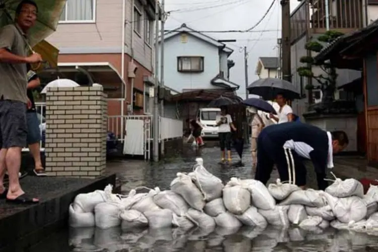 Moradores fazem barricadas para conter inundação provocada pelo tufão Talas (Getty Images)