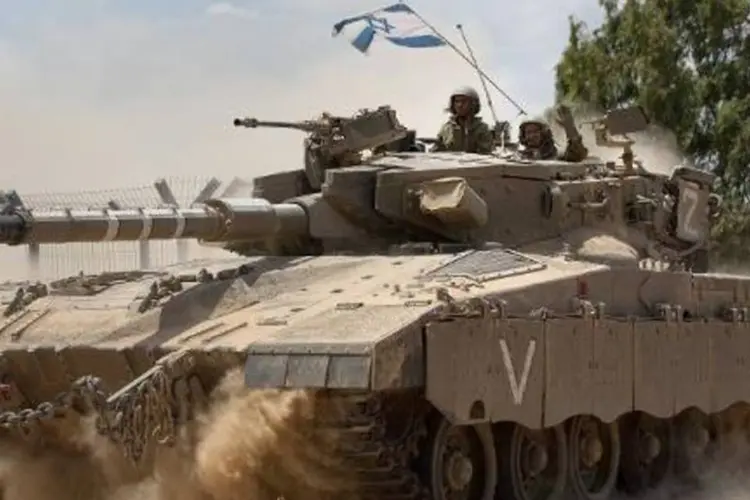 Soldado israelense em um tanque que se dirige à fronteira com a Faixa de Gaza (Menahem Kahana/AFP)