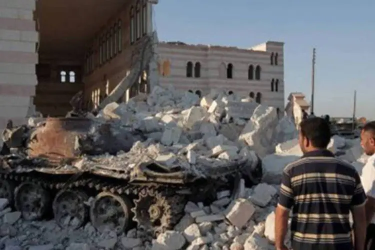 Alepo, norte da Síria: civis observam tanque do exército destruído em frente a mesquita (Ahmad Gharabli/AFP)
