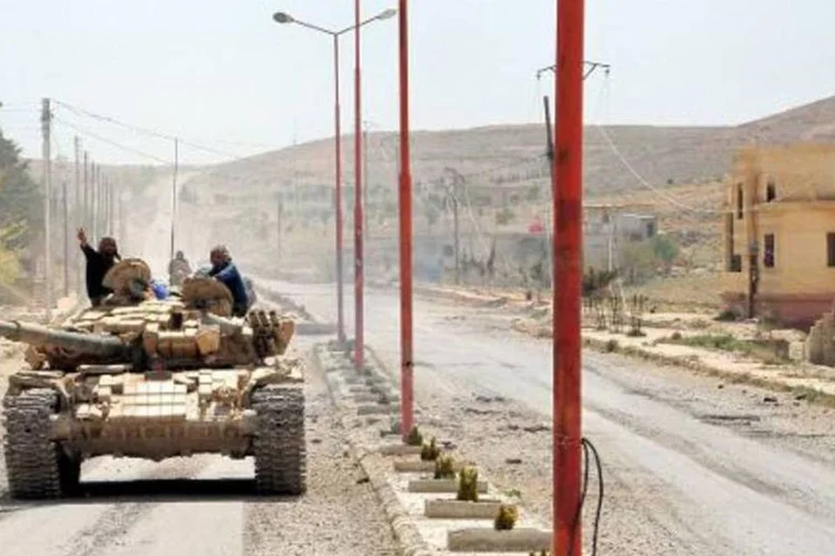 Tanques das forças do governo na aldeia de al-Sakhra, Síria: uma criança morreu e outras 41 pessoas, em sua maioria crianças, ficaram feridas, diz nota do governo (AFP)