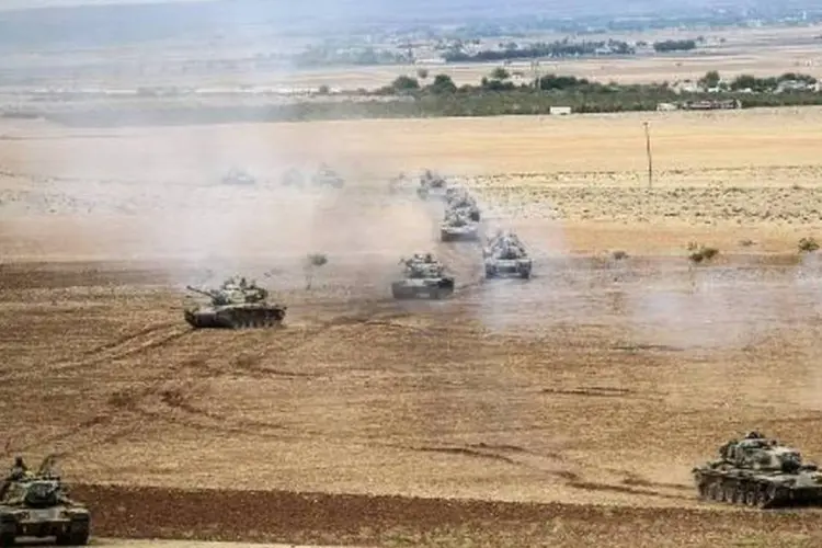 
	Tanques turcos na fronteira com a S&iacute;ria: 18 pessoas morreram
 (Bulent Kilic/AFP)