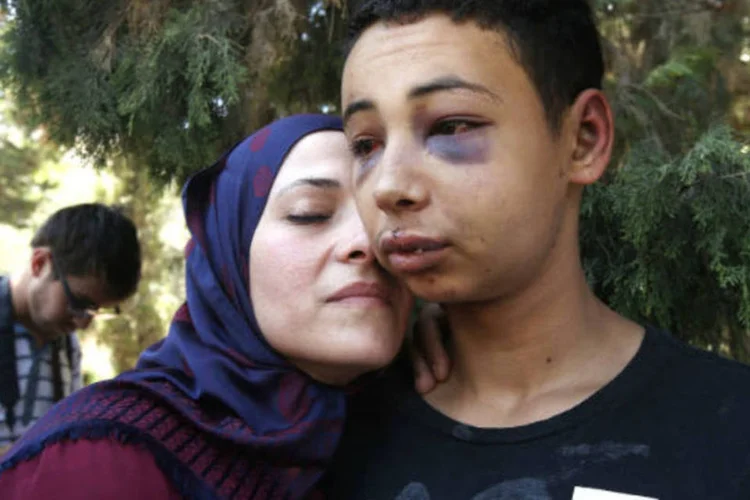 
	Tariq Khdeir, primo de Mohammed Abu Khudeir, &eacute; abra&ccedil;ado pela m&atilde;e. Morte levou a novos ataques
 (REUTERS/Ronen Zvulun)