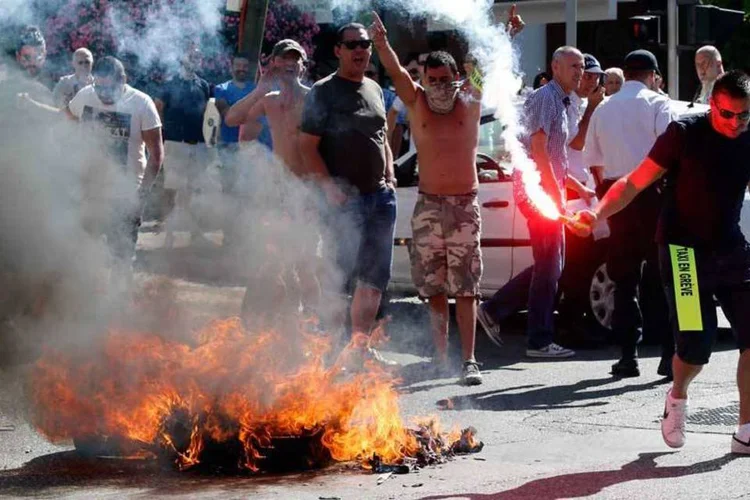 
	Taxistas queimam objetos em protesto contra Uber, em Paris: uma lei de outubro de 2014 baniu a rela&ccedil;&atilde;o de clientes com motoristas n&atilde;o registrados
 (REUTERS/Jean-Paul Pelissier)