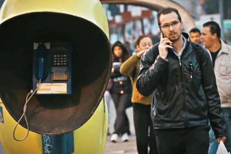 
	Homem fala ao celular na rua enquanto passa por orelh&otilde;es:&nbsp;&iacute;ndice que mede o tempo m&eacute;dio mensal de uso do celular por usu&aacute;rio subiu 13%
 (Robson Ventura/EXAME.com)