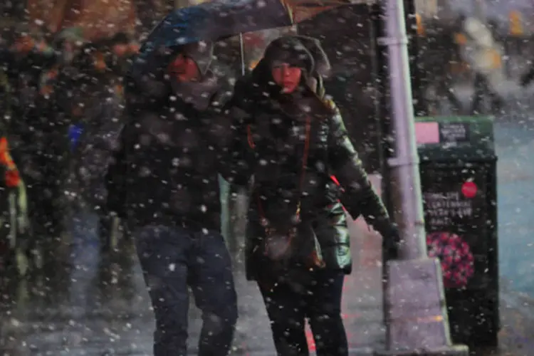 
	Pessoas caminham na Time Square durante uma tempestade de inverno: h&aacute; previs&atilde;o de neve para Nova York, Vermont e New Hampshire, com ventos de at&eacute; 48 km/h
 (Eduardo Munoz/Reuters)