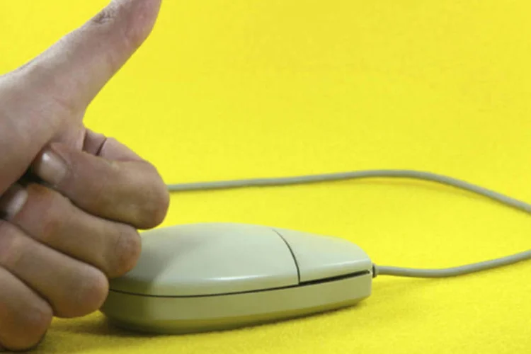 Mouse e mão com sinal positivo: (Vangelis Thomaidis/iStockphoto)