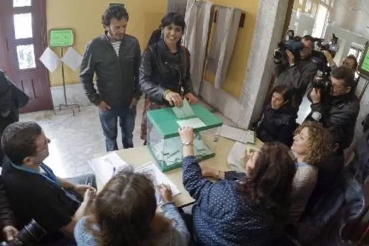 Teresa Rodríguez (C, D), candidata do Podemos pela Andaluzia, posa para fotos ao colocar seu voto na urna, em colégio eleitoral em Cádiz (Gogo Lobato/AFP)