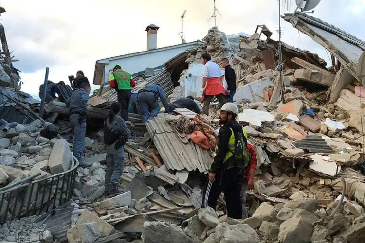 
	Escombros: dezenas de socorristas trabalhando com c&atilde;es farejadores escalavam pilhas de detritos tentando encontrar pessoas soterradas
 (Emiliano Grillotti/Reuters)