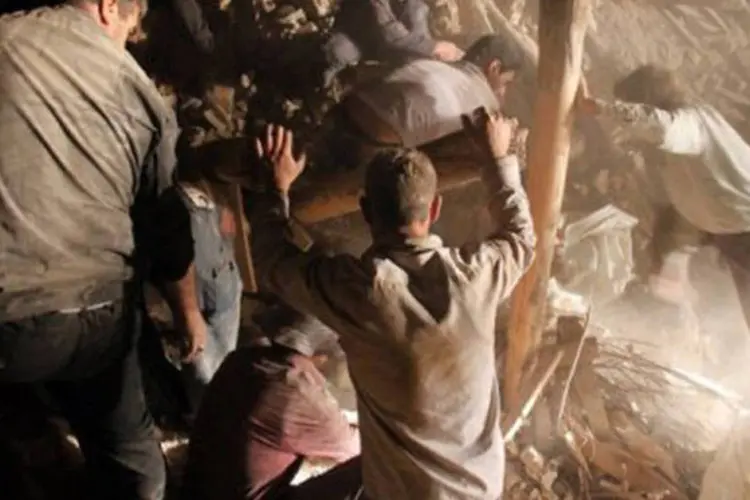 
	Equipe de resgate e moradores procuram por sobreviventes em escombros, no Ir&atilde;, em 11 de agosto: o Minist&eacute;rio do Interior anunciou no domingo o fim das opera&ccedil;&otilde;es de resgate
 (Farshid Tighehsaz/AFP)