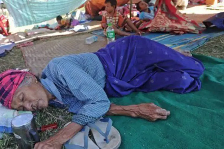 
	V&iacute;tima de terremoto em Mianmar descansa em campo para desabrigados em Mandalay: mais de 250 casas foram destru&iacute;das
 (Soe Than Win/AFP)