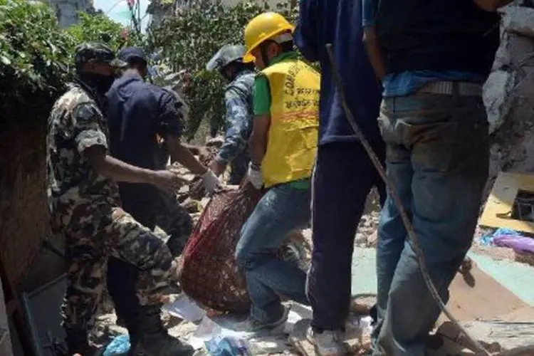 Cadáveres são retirados de escombros em Katmandu: ONU antecipou que será uma operação muito difícil devido à topografia montanhosa do país (Prakash Singh/AFP)