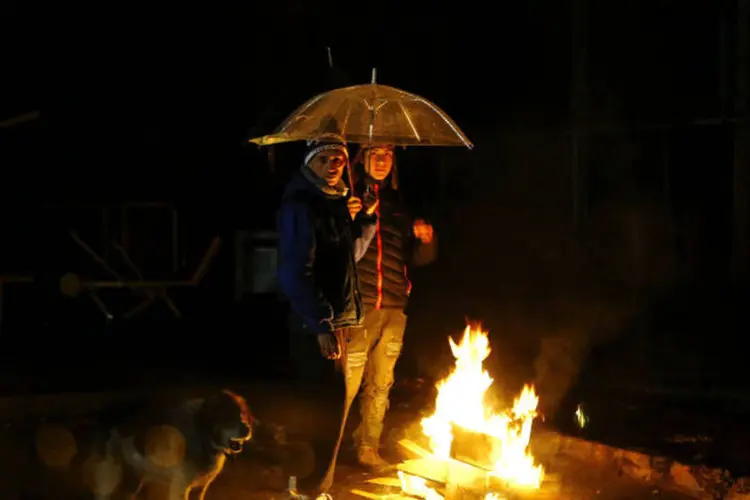 Pessoas em volta de uma fogueira após um apagão causado pelo terremoto no Chile, em Santiago (Ivan Alvarado/Reuters)