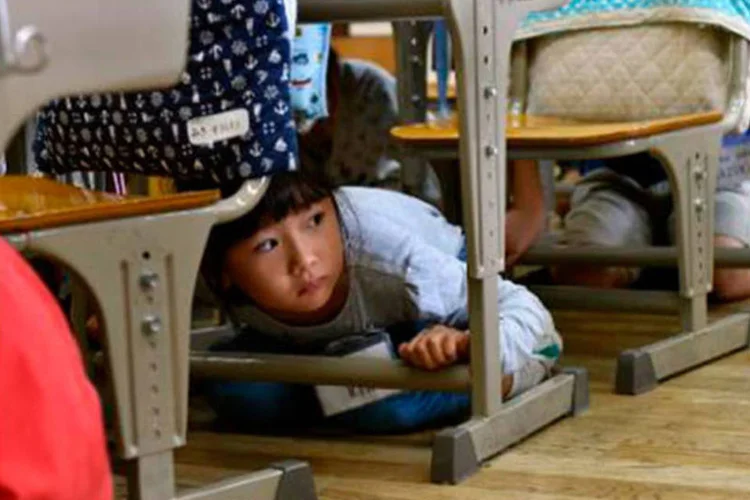 
	Crian&ccedil;as participam em exerc&iacute;cio de rea&ccedil;&atilde;o a terremotos em escola de T&oacute;quio
 (Yoshikazu Tsuno/AFP)