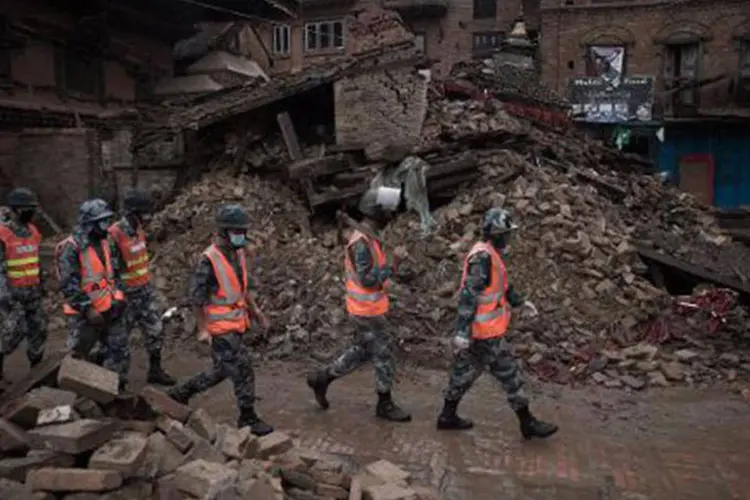 Equipes de resgate caminham por escombros em área considerada patrimônio mundial pela Unesco em Bhaktapur, na região da capital Kathmandu
 (Niccolas Asfouri/AFP)