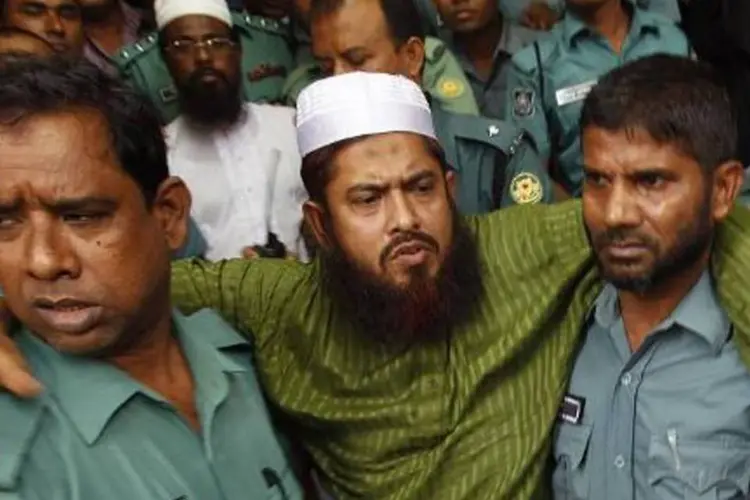 Líder do grupo Harkat-ul-Jihad al Islami, Mufti Abdul Hannan, escoltado por policiais antes do julgamento (AFP)