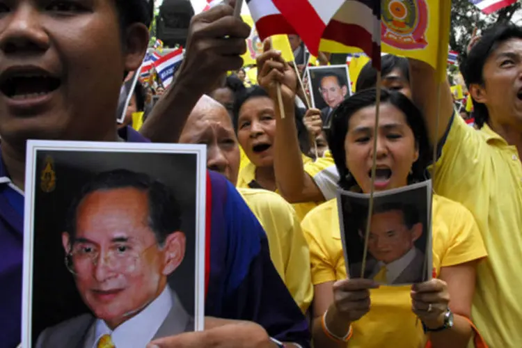 Pessoas com fotografias de Bhumibol Adulaydej: saúde do rei já foi motivo de agitação nos mercados financeiros da Tailândia, já que é visto como uma figura unificadora (.)