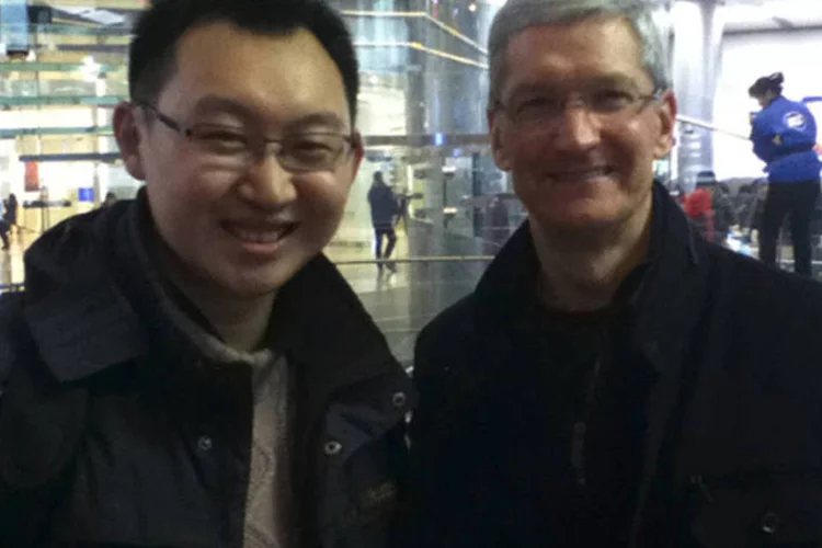 CEO da Apple, Tim Cook, posa com consumidor em uma Apple Store em Pequim, em sua visita a China (Divulgação/Reuters)