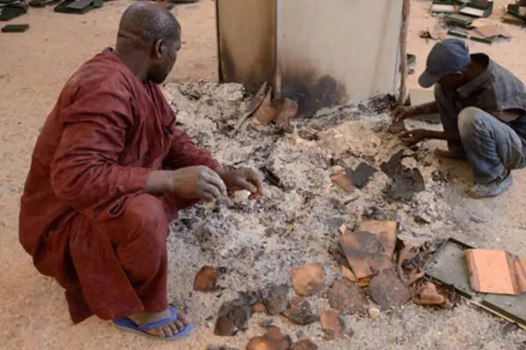
	Homens tentam recuperar manuscritos queimados, no Centro de Documenta&ccedil;&atilde;o e Pesquisas Ahmed Baba, em Timbuktu
 (AFP/ Eric Feferberg)