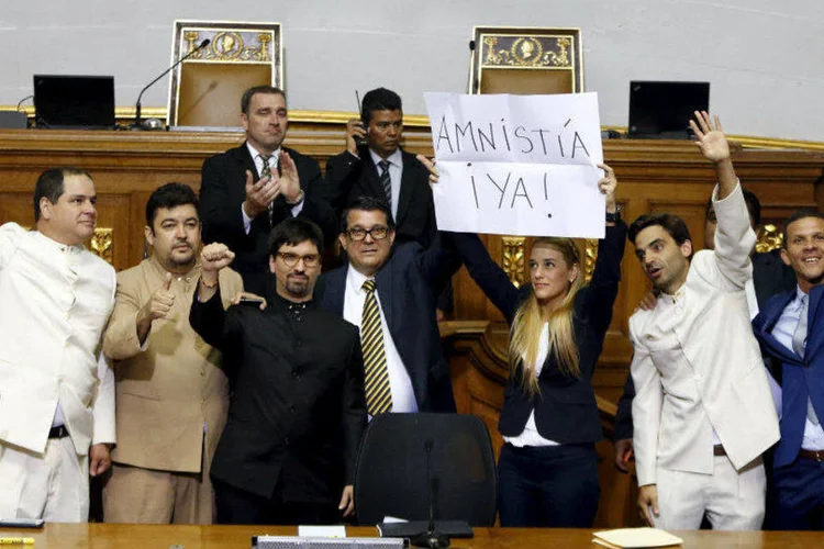 
	Lilian Tintori, esposa do opositor Leopoldo Lopez, levanta uma placa escrito &quot;Anistia agora&quot; antes da sess&atilde;o na Assembleia Nacional em Caracas
 (Carlos Garcia Rawlins/Reuters)