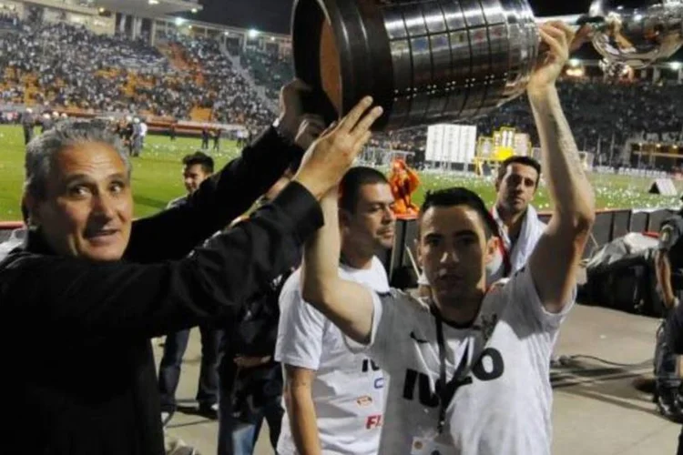 Técnico Tite (à esquerda) ergue taça da Libertadores com o Corinthians: No Facebook é possível registrar uma enxurrada de posts comemorando o título inédito (Reuters)