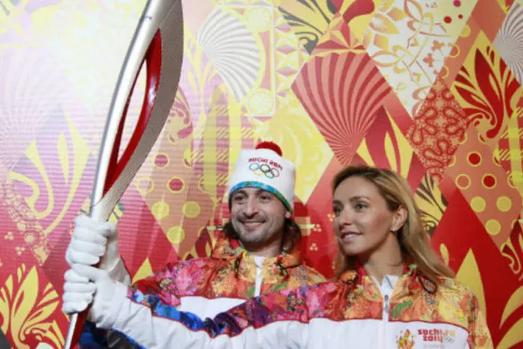 
	Dan&ccedil;arinos do gelo russos Tatyana Navka e Ilya Averbukh seguram a tocha ol&iacute;mpica para os Jogos de Inverno de Sochi, que acontecer&atilde;o em 2014
 (REUTERS / Maxim Shemetov)