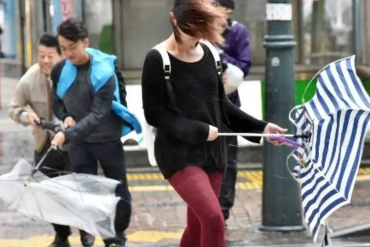 Moradores de Tóquio enfrentam os fortes ventos e a chuva na capital do Japão (Yoshikazu Tsuno/AFP)