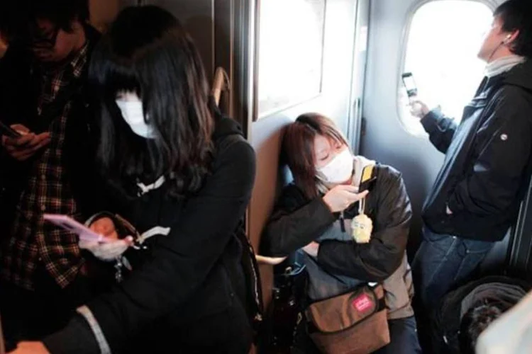 Trem saindo de Tóquio: pessoas usam máscaras por temor de contaminação (Adam Pretty/Getty Images)