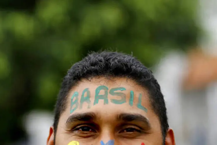 Torcedor do Brasil com rosto enfeitado (Kai Pfaffenbach / Reuters)