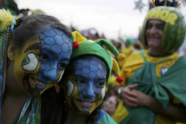 Torcedoras posam para uma foto durante partida do Brasil contra Camarões, em Copacabana (Pilar Olivares/Reuters)