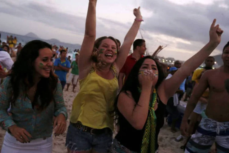 Torcedoras comemoram gol do Brasil em Copacabana, no dia 12 de junho (Pilar Olivares / Reuters)