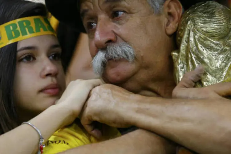 No Mineirão, torcedor brasileiro se agarra à réplica da taça da Copa do Mundo como consolo pela derrota para a Alemanha (Damir Sagolj/Reuters)