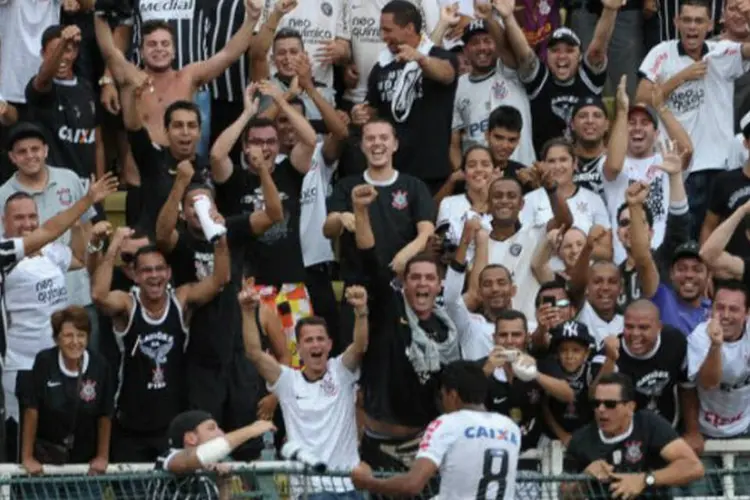 
	Torcedores do Corinthians comemoram gol da equipe durante partida do Campeonato Paulista de 2013
 (AFP / Yasuyoshi Chiba)