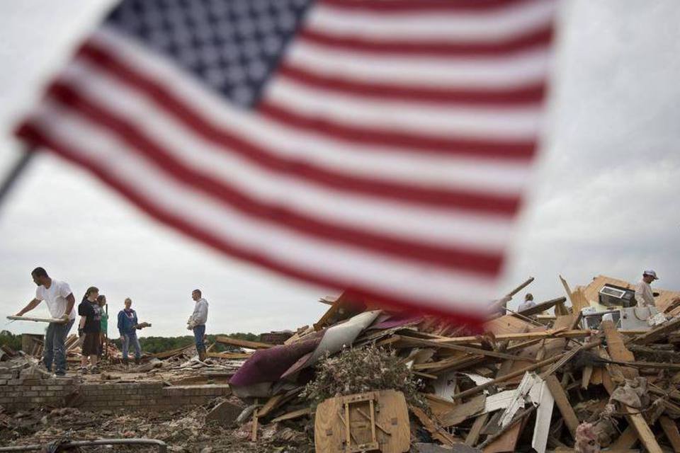 Trabalhadores limpam os destroços de uma casa afetada pelos tornados que atingiram os Estados Unidos, em Mayflower, Arkansas (Carlo Allegri/Reuters)