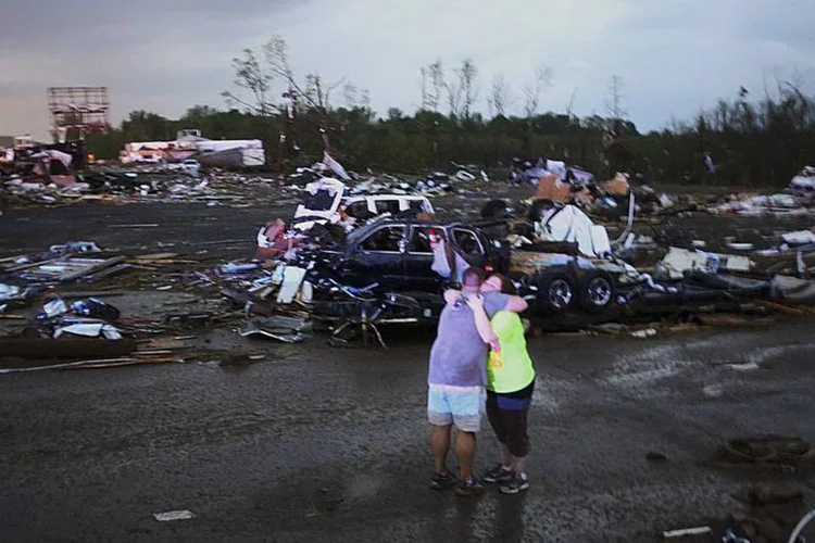 Moradora é consolada após buscas por seu cachorro após um tornado que atingiu a cidade de Mayflower, Arkansas  (Kathryn Piotrowski/TwisterChasers.com/Reuters)