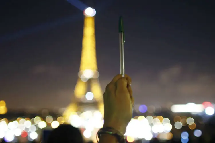 
	Caneta e Torre Eiffel apagando as luzes: ato foi em solidariedade aos mortos em atentado
 (Charles Platiau/Reuters)