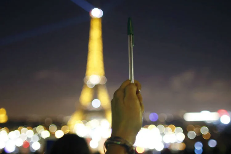 Caneta e Torre Eiffel apagando as luzes: ato foi em solidariedade aos mortos em atentado (Charles Platiau/Reuters)
