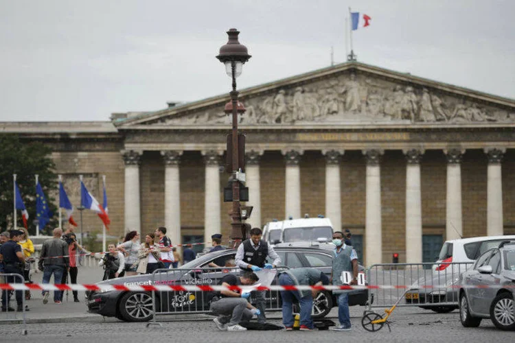 
	Policiais recolhem provas ap&oacute;s ve&iacute;culo romper barreira perto da chegada do Tour de France, em Paris: motorista ainda &eacute; procurado
 (REUTERS/Stephane Mahe)