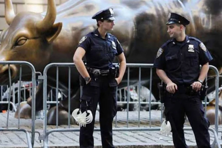 Polícia guarda o touro símbolo do mercado financeiro durante protesto do Occupy Wall Street: movimento quer quitar dívidas com doações (Mario Tama/Getty Images)