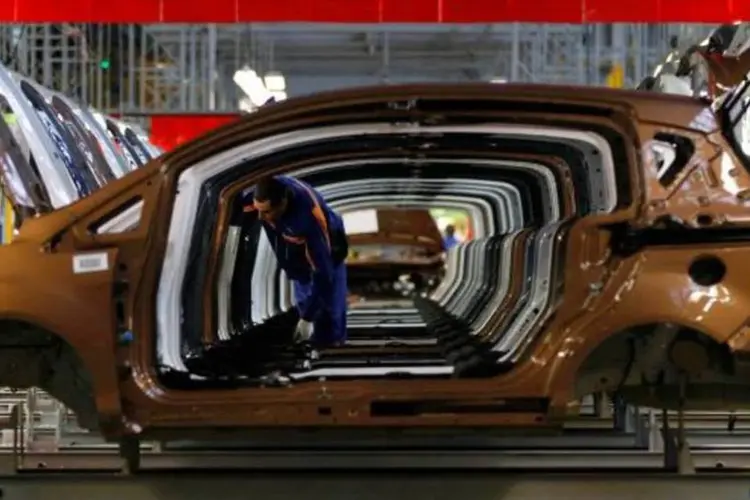 Trabalhador checa carros em linha de montagem da Ford (Bogdan Cristel/Reuters)