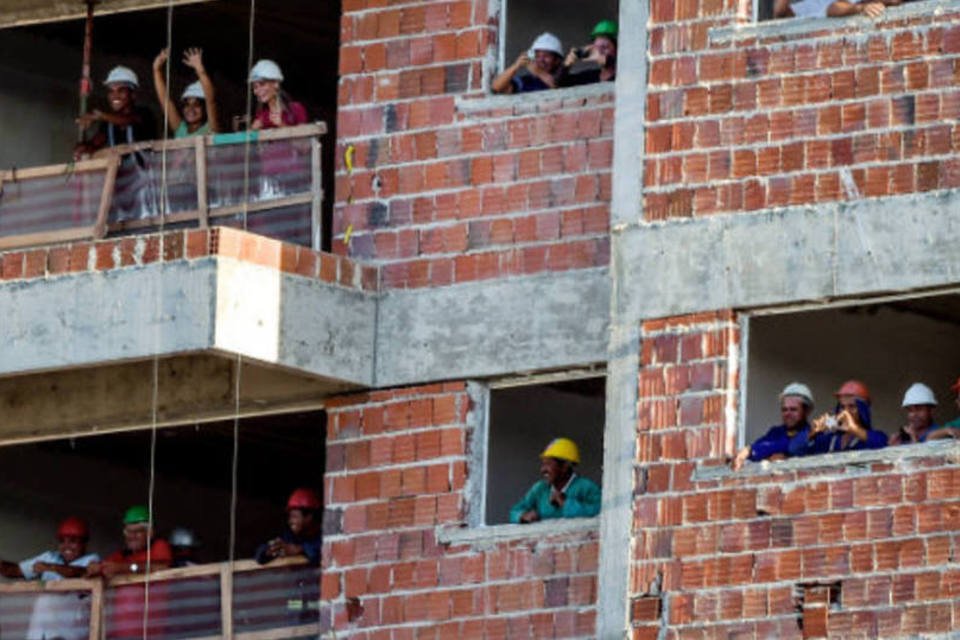 Do alto da obra, trabalhadores assistem ao treino do Brasil