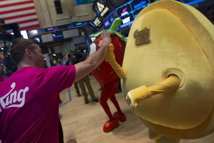Trader cumprimenta um mascote da King Digital Entertainment, produtora do "Candy Crush", durante a IPO da companhia na Bolsa de Nova York (NYSE), no dia 26 de março de 2014 (Jin Lee/Bloomberg)