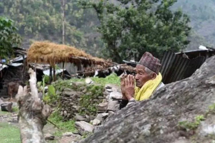 Nepalês reza após terremoto detruir seu vilarejo em Lapu (Sajjad Hussain/AFP)