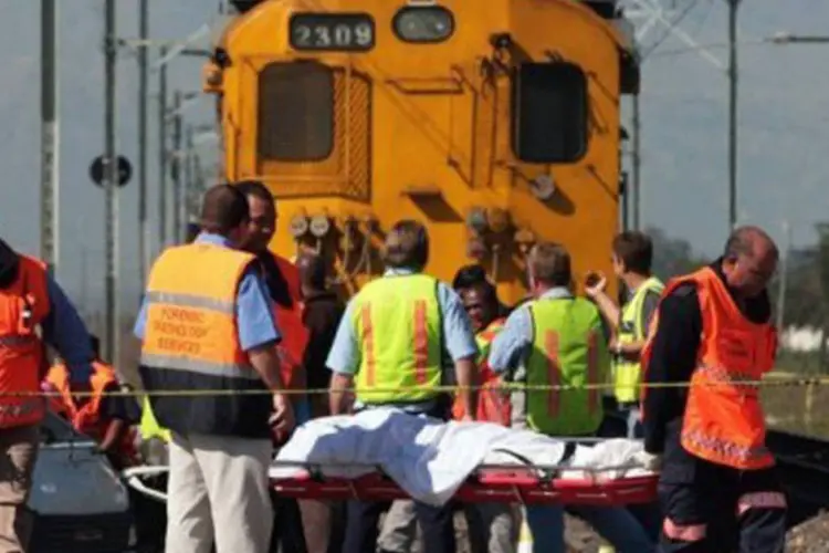 Paramédicos retiram corpos de vítimas de acidente ferroviário perto da Cidade do Cabo em agosto de 2010: o caminhão transportava cerca de 50 trabalhadores agrícolas (AFP)