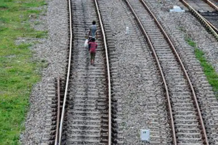 
	Pessoas andam por trilho de trem: o acidente pode ter sido provocado por falha humana
 (Diptendu Dutta/AFP)