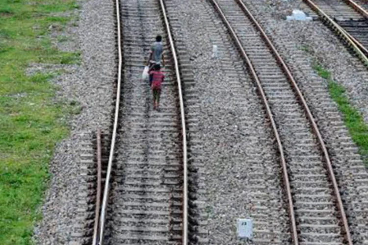 
	Pessoas andam por trilho de trem: o acidente pode ter sido provocado por falha humana
 (Diptendu Dutta/AFP)