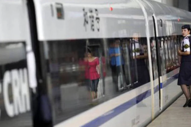 
	Uma funcion&aacute;ria observa o embarque dos passageiros em trem: a pol&iacute;cia tamb&eacute;m&nbsp;&quot;aconselha&quot;&nbsp;&agrave;s mulheres que se cubram com bolsas ou jornais quando se sentarem nos ve&iacute;culos
 (Liu Jin/AFP)